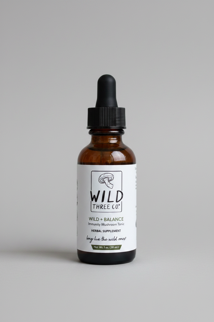 Amber tincture bottle with an immunity mushroom tonic for daily use. The lid is black. The label is white with black and green font. The front of the label has their logo, name of product and their tag line.  